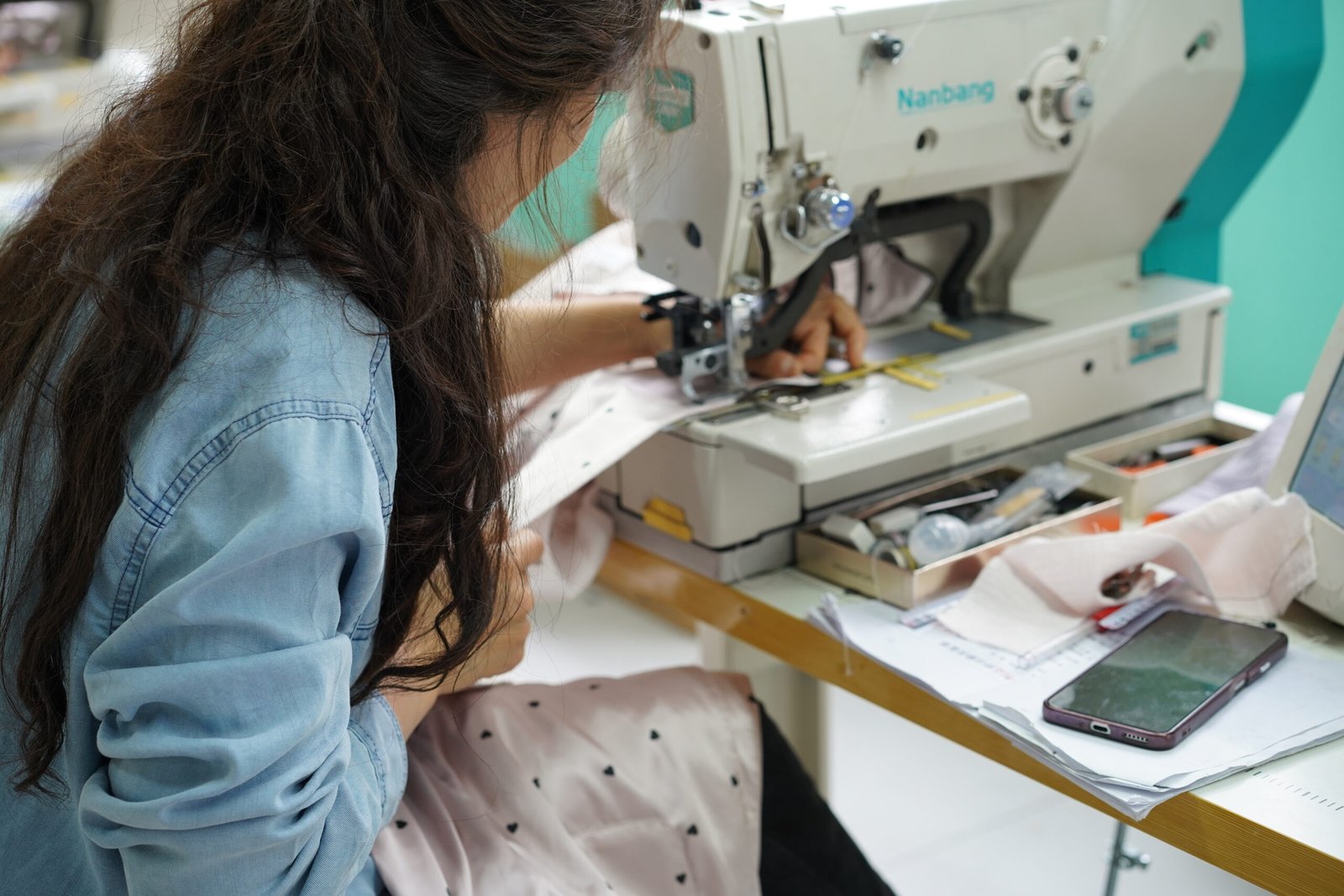 Button attachment machine for sleepwear production